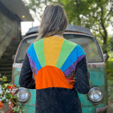 A woman wearing the black Sun Ray Cardigan in front of a vintage Volkswagen bus.