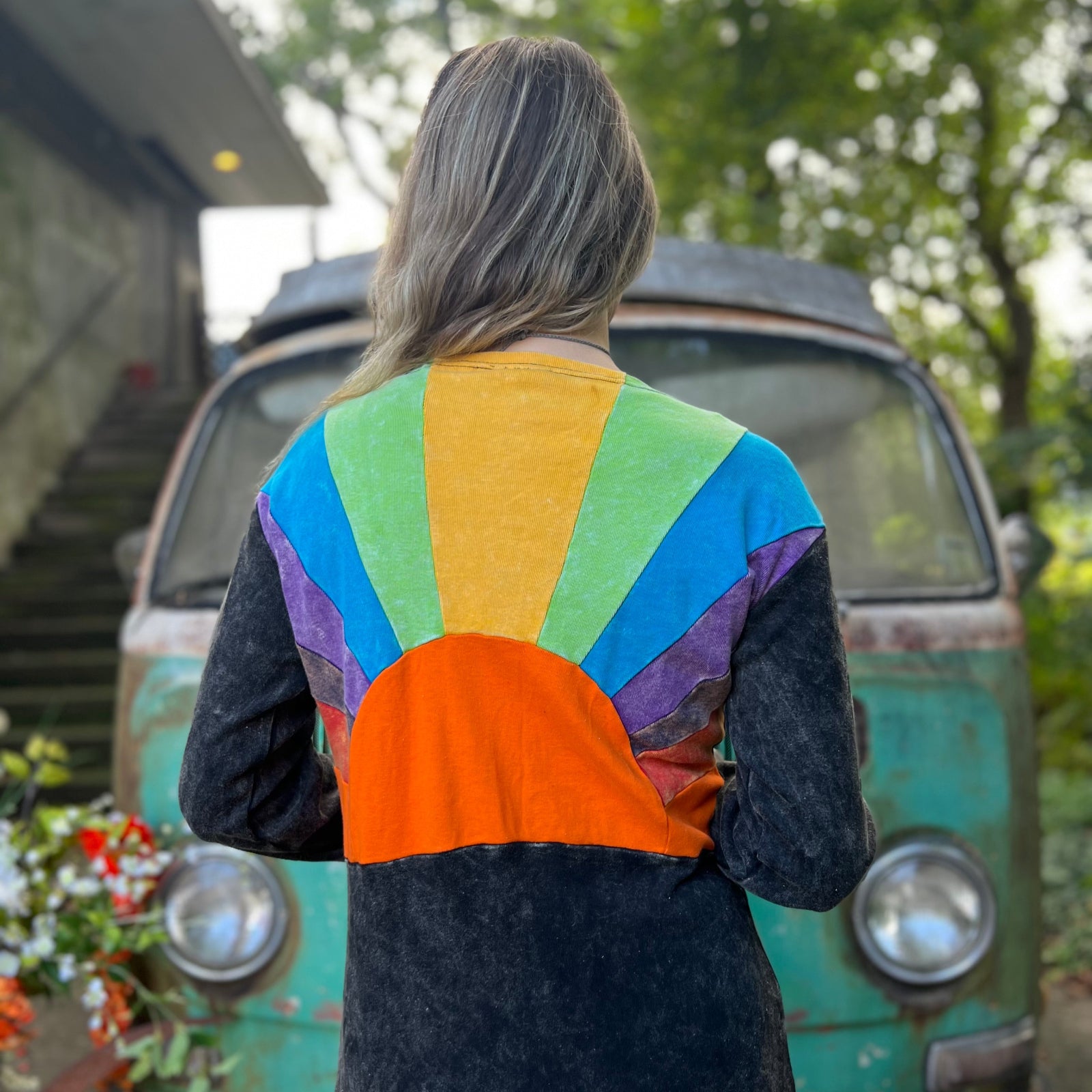 A woman wearing the black Sun Ray Cardigan in front of a vintage Volkswagen bus.