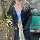 A woman wearing the black Sun Ray Cardigan in front of a vintage Volkswagen bus.