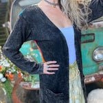 A woman wearing the black Sun Ray Cardigan in front of a vintage Volkswagen bus.