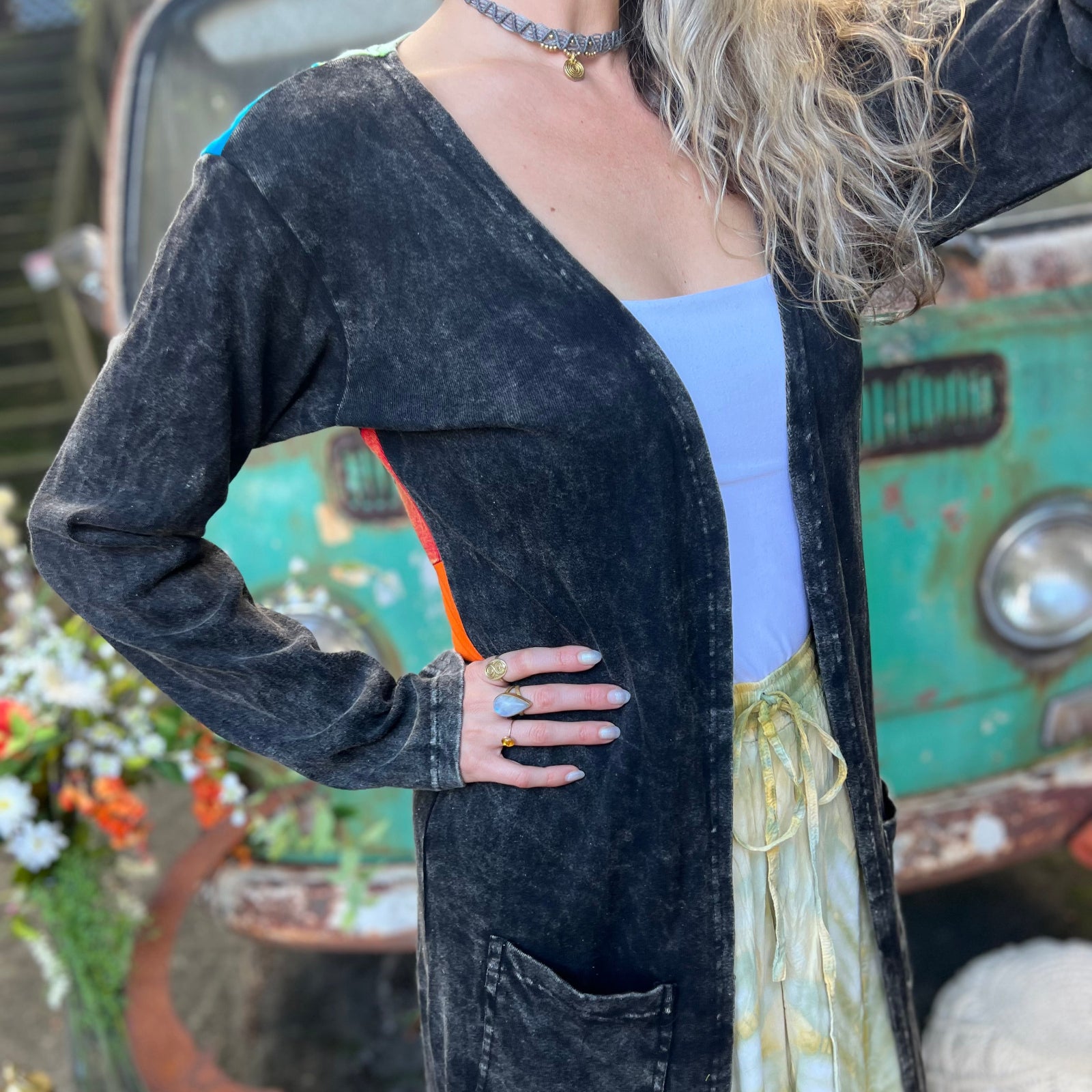 A woman wearing the black Sun Ray Cardigan in front of a vintage Volkswagen bus.