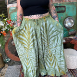 A woman wearing the green Hippie Bohemian Hand Dyed Palazzo Pants in front of a vintage Volkswagen bus.