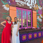 The ivory and red heaven corset flutter dresses in front of the Boho Depot store.