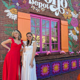 The ivory and red heaven corset flutter dresses in front of the Boho Depot store.