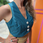 A woman wearing the blue Rustic Stripe Fitted Vest with a tan tank and striped pants.