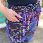 A woman wearing the Cotton Block Print Batik Cutwork Pants in front of a vintage Volkswagen bus.