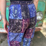 A woman wearing the Cotton Block Print Batik Cutwork Pants in front of a vintage Volkswagen bus.