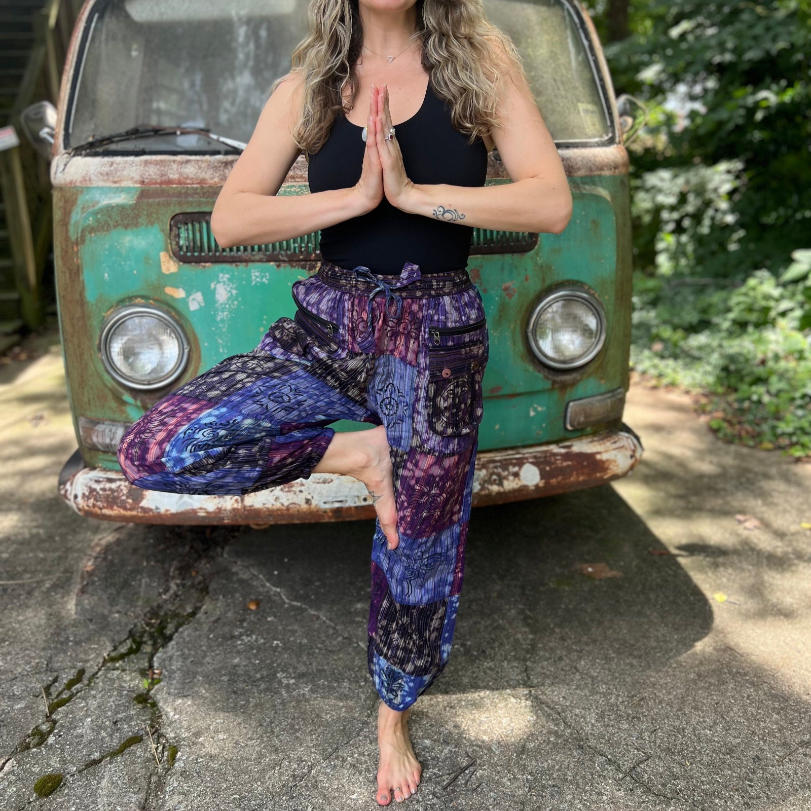 A woman wearing the Cotton Block Print Batik Cutwork Pants in front of a vintage Volkswagen bus.