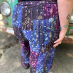 A woman wearing the Cotton Block Print Batik Cutwork Pants in front of a vintage Volkswagen bus.