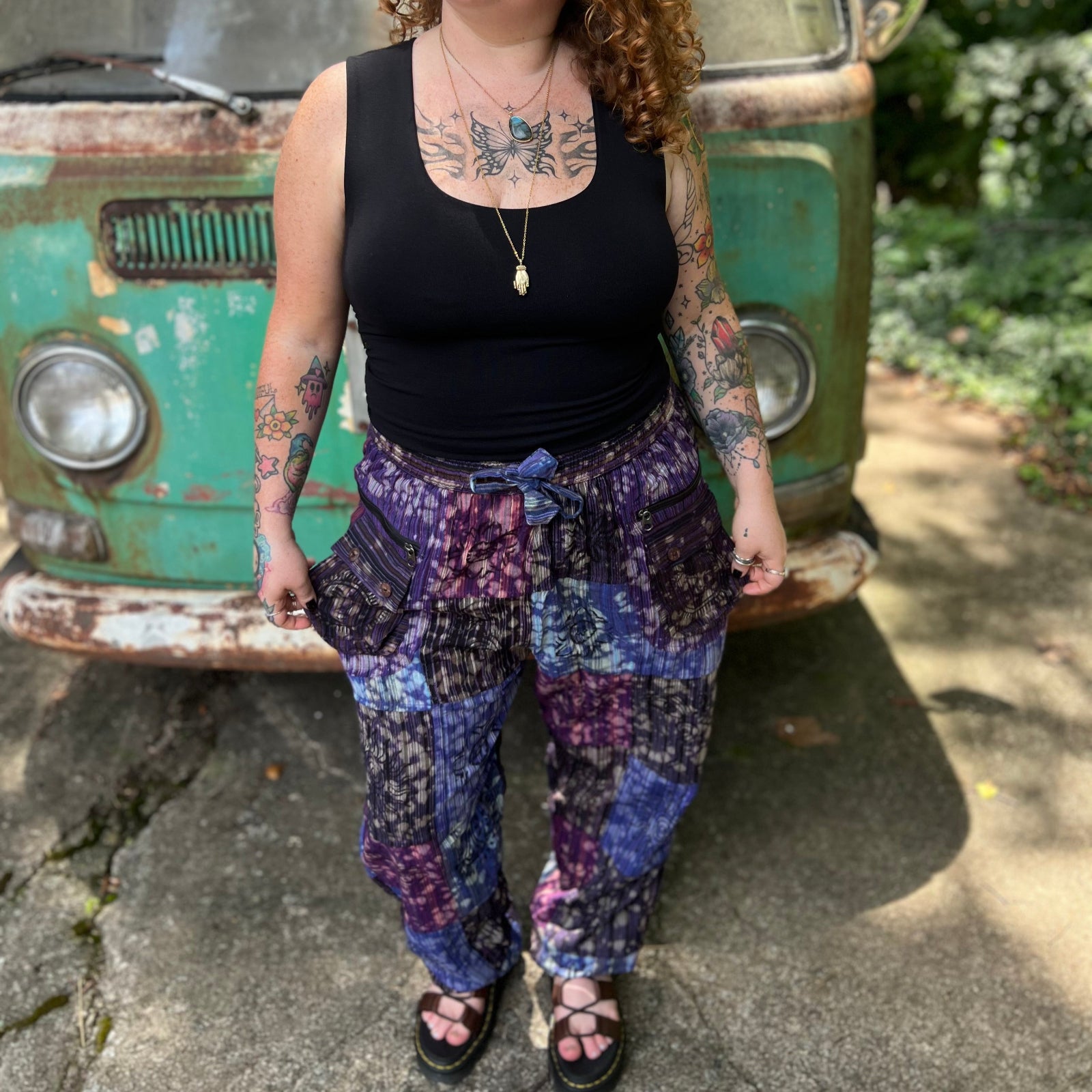 A woman wearing the Cotton Block Print Batik Cutwork Pants in front of a vintage Volkswagen bus.