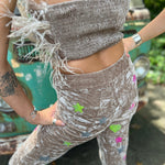 A woman wearing the beige Feather Crop Top with Stretch Flared Pants Set in front of a vintage teal Volkswagen bus.
