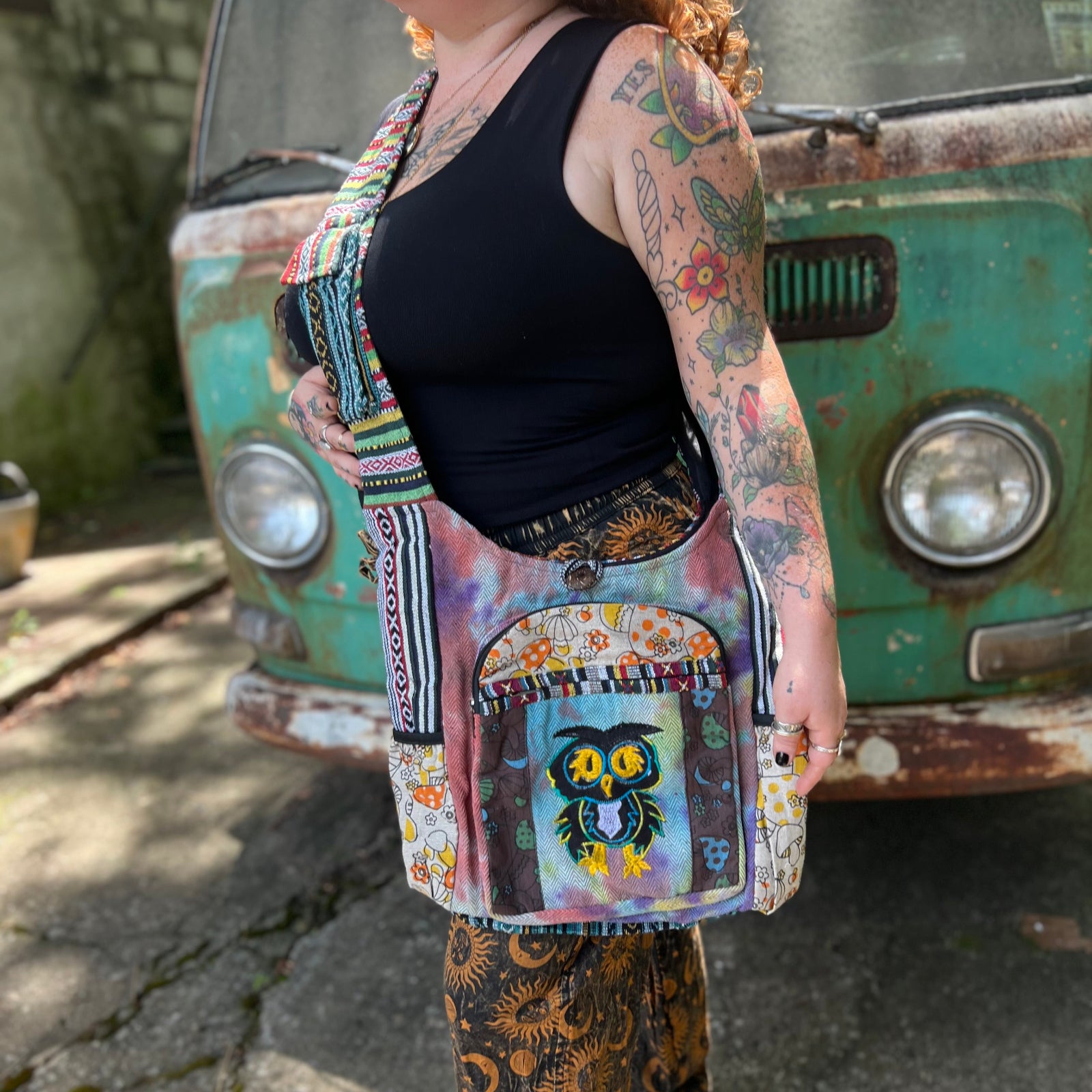 Someone wearing the Tie Dye Owl with Mushroom Cotton & Hemp Pocket Bag in front of a vintage Volkswagen bus.