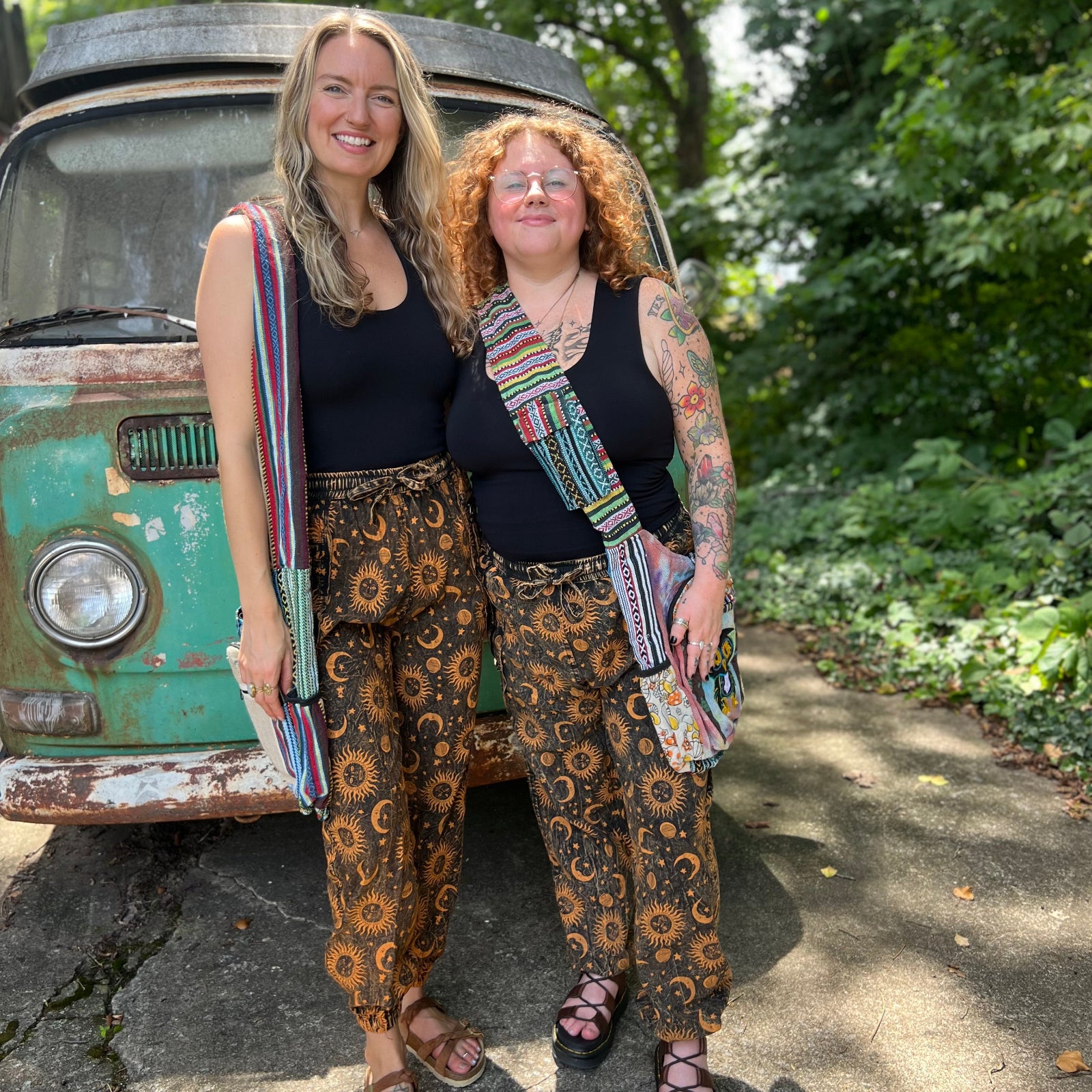 Two women wearing the Cotton Stonewash Golden Sun Moon Cargo Pants in front of a vintage Volkswagen bus.