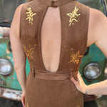 A woman wearing the camel Suede Sequin Embellished Embroidered Bootcut Jumpsuit in front of a teal vintage Volkswagen bus.
