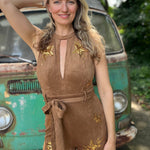 A woman wearing the camel Suede Sequin Embellished Embroidered Bootcut Jumpsuit in front of a teal vintage Volkswagen bus.