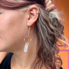 Someone wearing the brass Quartz Crystal Drop Earrings.