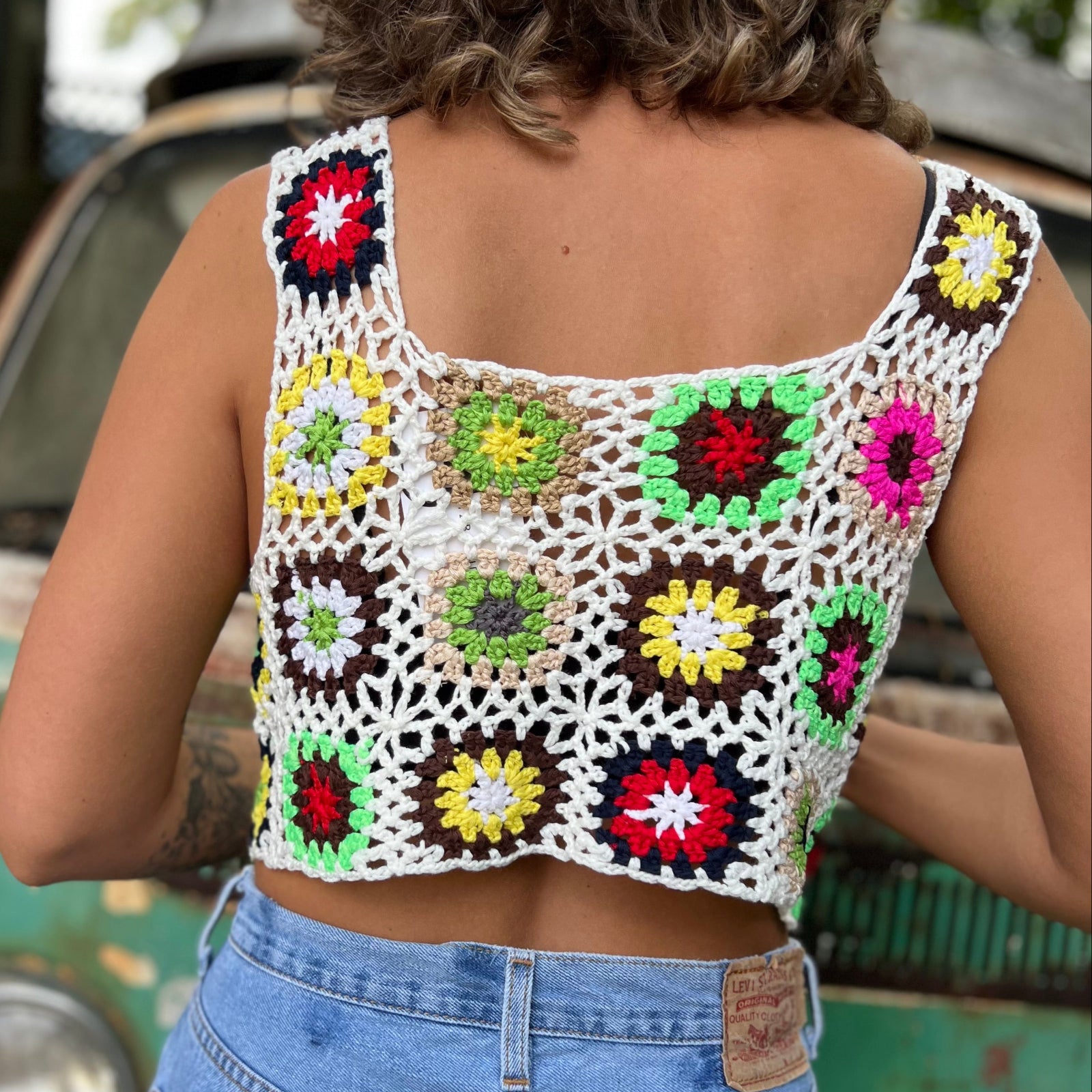 Someone wearing the white Handmade Boho Crochet Design Camisole in front of an old teal Volkswagen bus.