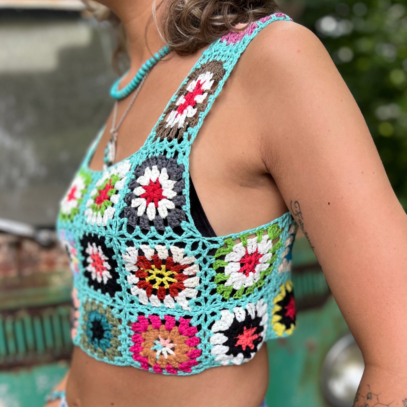 Someone wearing the blue Handmade Boho Crochet Design Camisole in front of an old teal Volkswagen bus.
