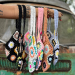All varieties of the Bohemian Handmade Crochet Bags on an arm in front of an teal Volkswagen bus.