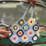 Someone holding the blue Bohemian Handmade Crochet Bag in front of a teal Volkswagen bus.