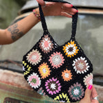 Someone holding the black Bohemian Handmade Crochet Bag in front of an old teal Volkswagen bus.
