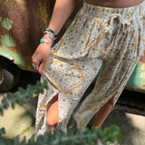 Someone wearing the Honey Linen Pants with Front Slit with a white bralette.