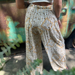 Someone wearing the Honey Linen Pants with Front Slit with a white bralette.