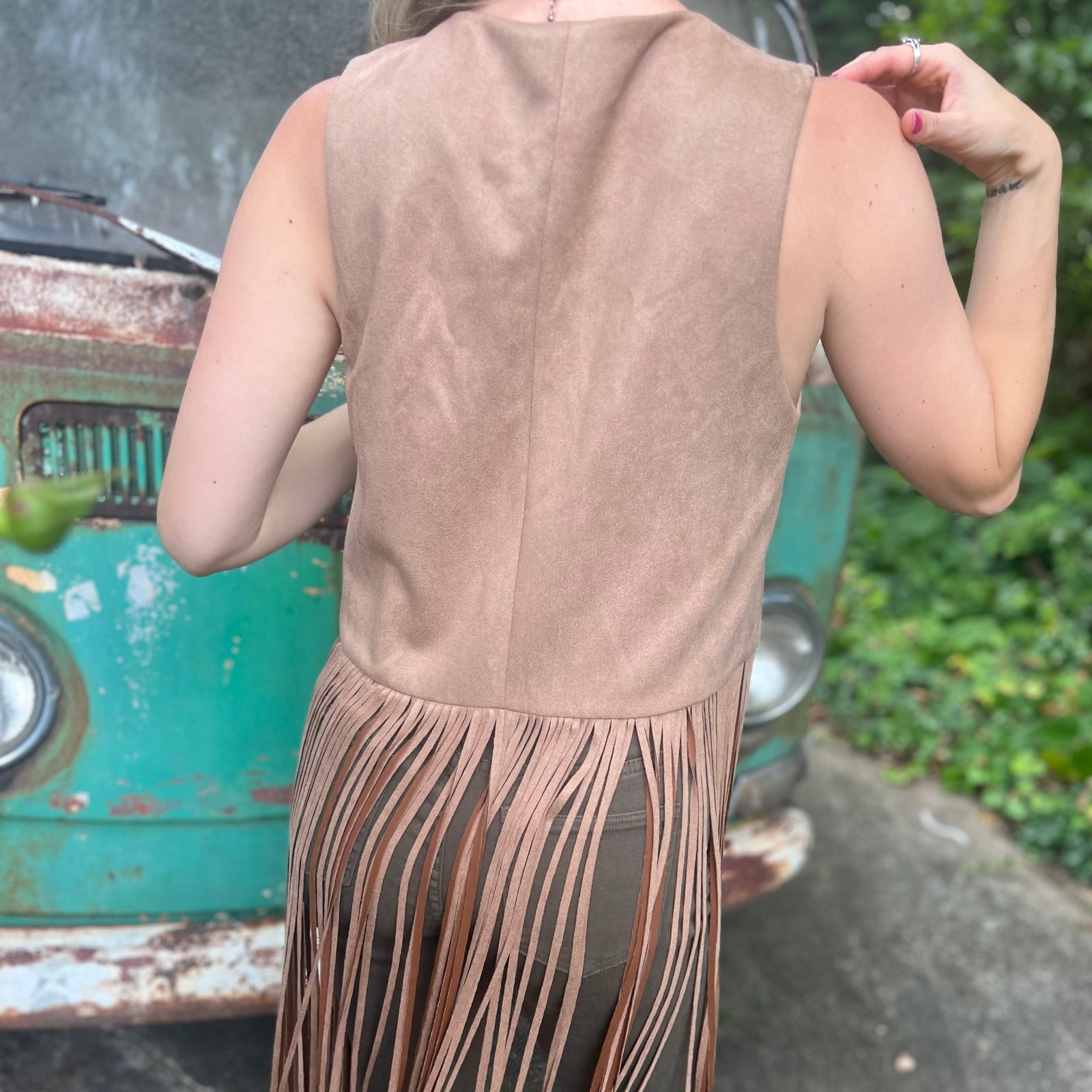 A woman wearing the tan Faux Suede Long Fringe Western Vest.