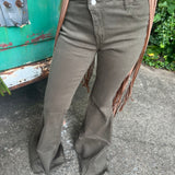 Someone wearing the Olive Criss Cross Upsized Bell Bottom Jean with a fringe vest.