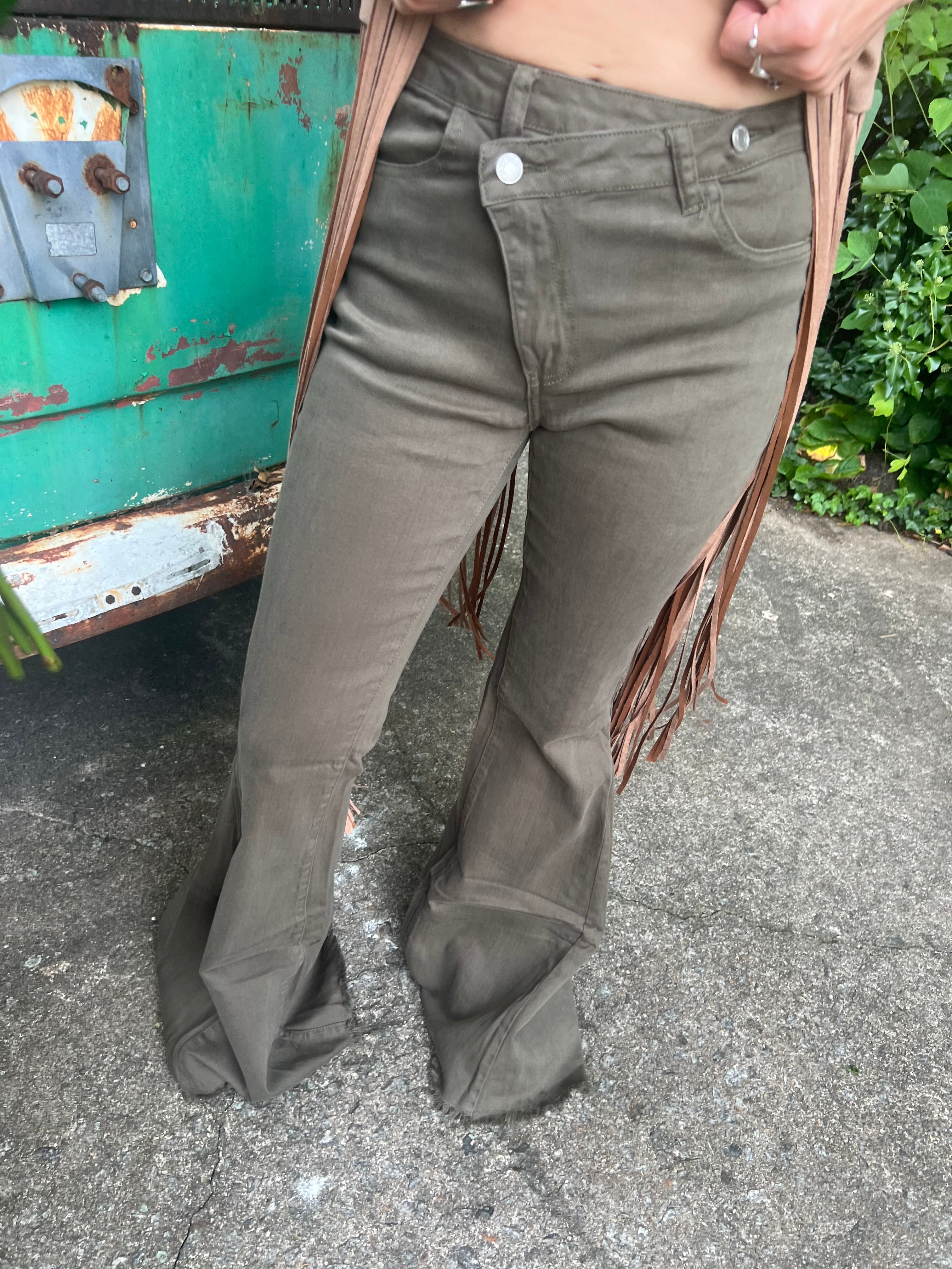 Someone wearing the Olive Criss Cross Upsized Bell Bottom Jean with a fringe vest.