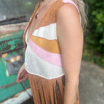 A woman wearing the camel Retro Sunburst Suede Color Block Long Fringe Faux Vest.