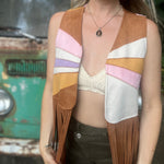 A woman wearing the camel Retro Sunburst Suede Color Block Long Fringe Faux Vest.