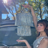 Someone holding the Disco Party Chandelier in front of a vintage teal Volkswagen bus.