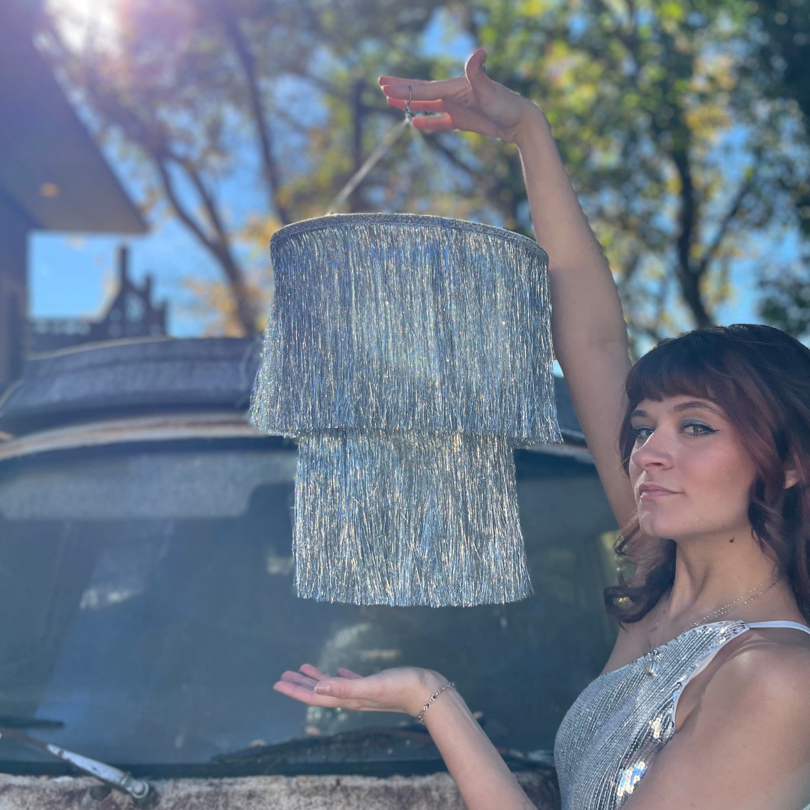 Someone holding the Disco Party Chandelier in front of a vintage teal Volkswagen bus.