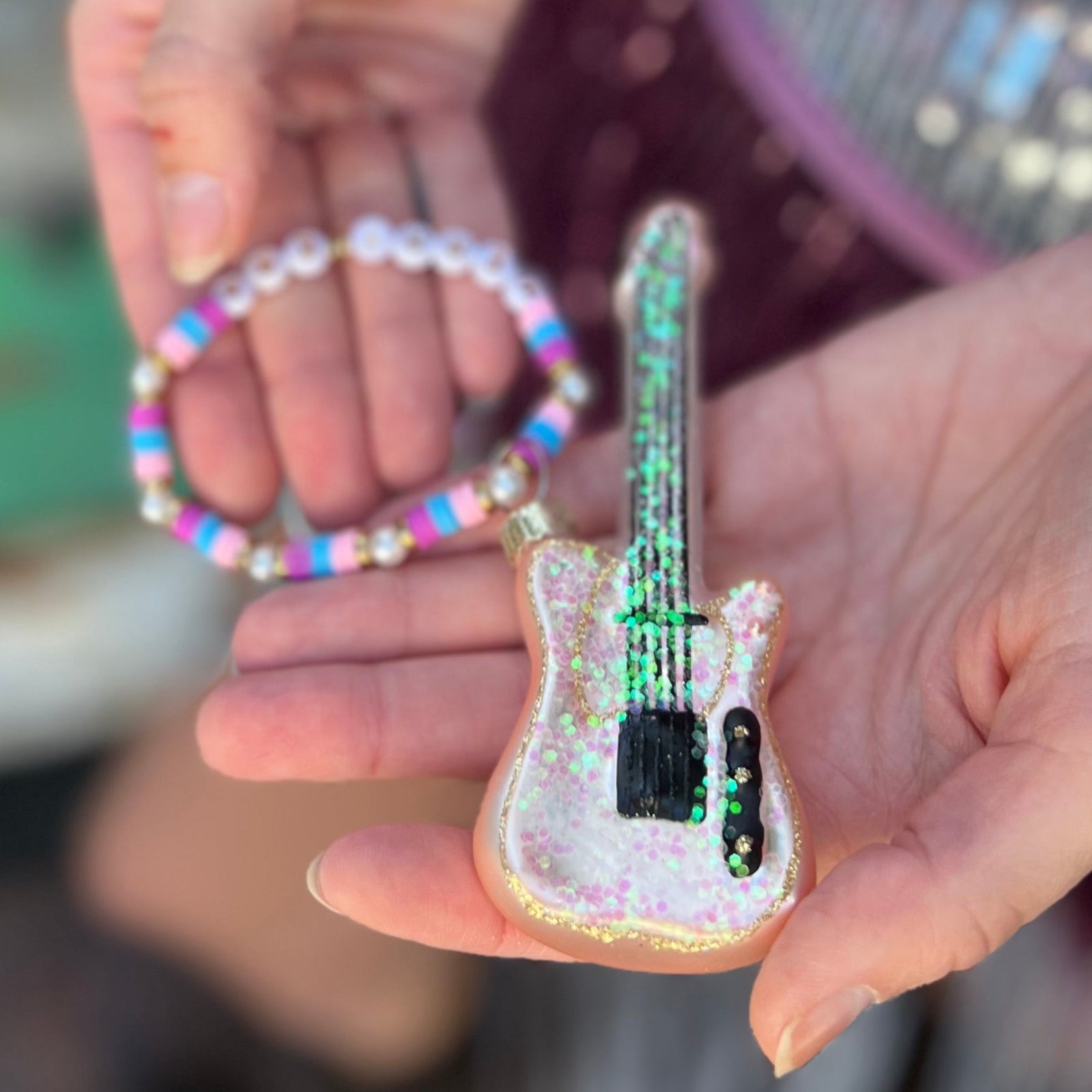 Someone holding the Merry Era Friendship Bracelet Ornament.