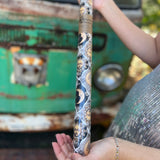 Someone holding the Sun and Moon Harlequin Collage Matte Fine Wrapping Paper in front of a vintage teal Volkswagen bus.
