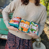 Someone holding three of the Tea Towel Sets from The Neighborgoods.