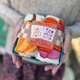Someone holding the Fall Feast Tea Towel Set of 2 in front of themselves.