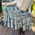 Someone wearing the indigo Tie Dye Gauze Cotton Skirt with a beige sweater in front of a vintage teal Volkswagen bus.