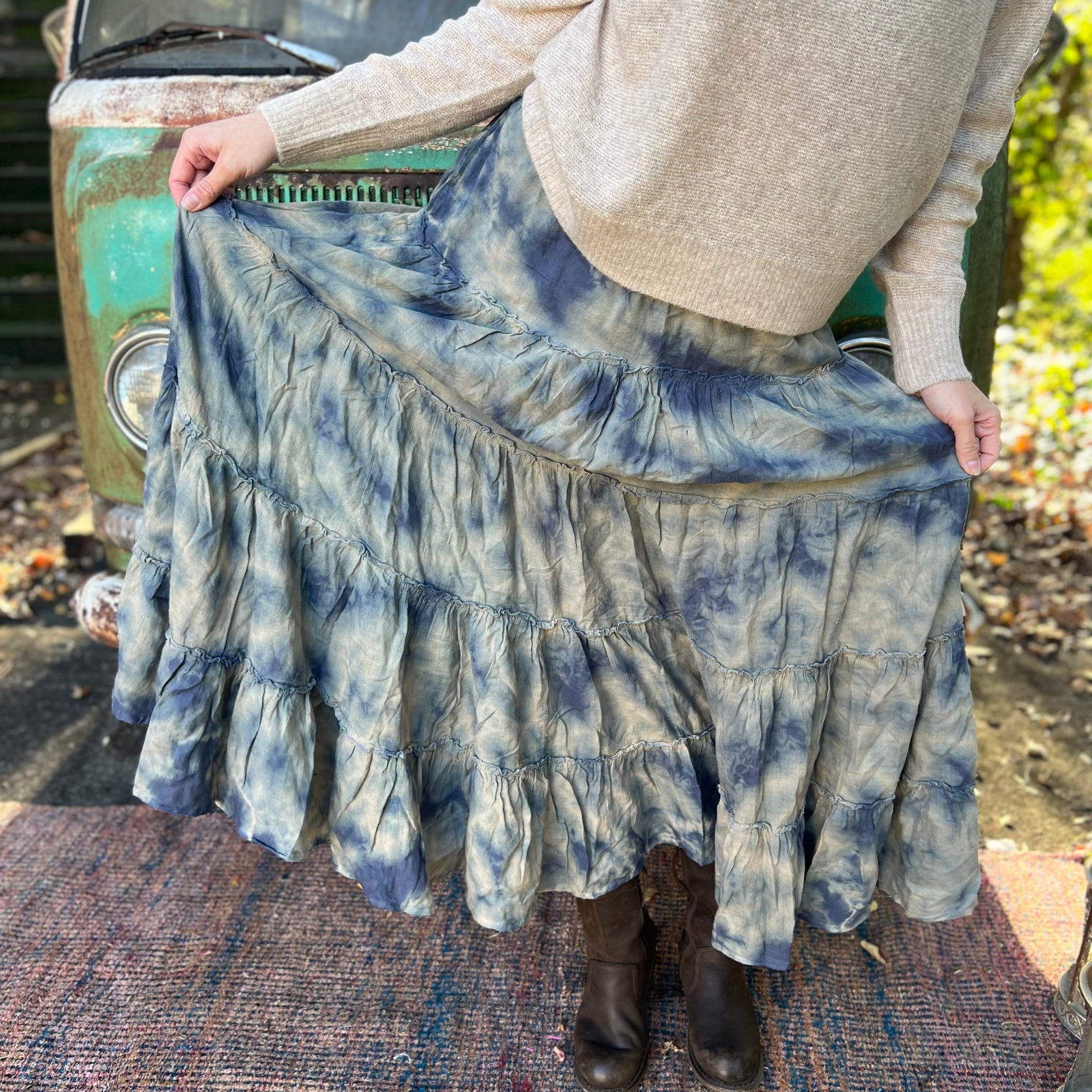 Someone wearing the indigo Tie Dye Gauze Cotton Skirt with a beige sweater in front of a vintage teal Volkswagen bus.