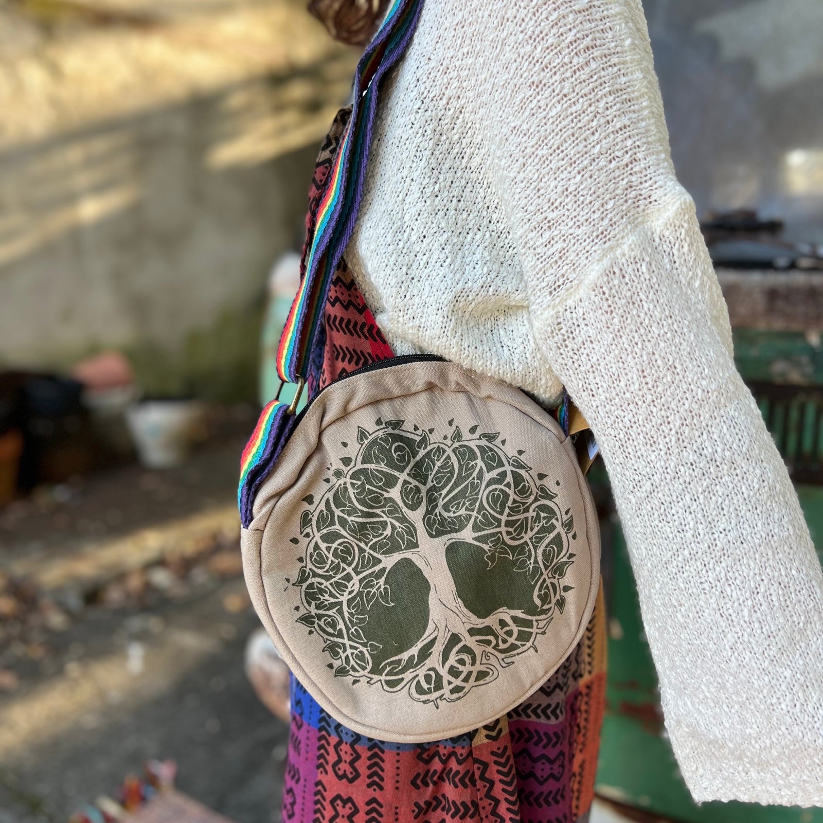 A woman wearing the tree Bohemian Round Print Cotton Crossbody Bag with a hippie jumpsuit.