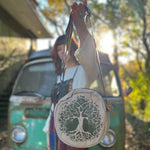 A woman holding the tree Bohemian Round Print Cotton Crossbody Bag in front of herself.