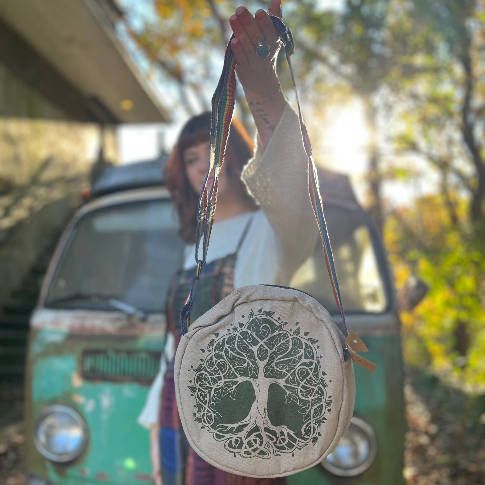 A woman holding the tree Bohemian Round Print Cotton Crossbody Bag in front of herself.