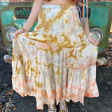 Someone wearing the sand Tie Dye Gauze Cotton Skirt with a burnt orange vest in front of a vintage teal Volkswagen bus.