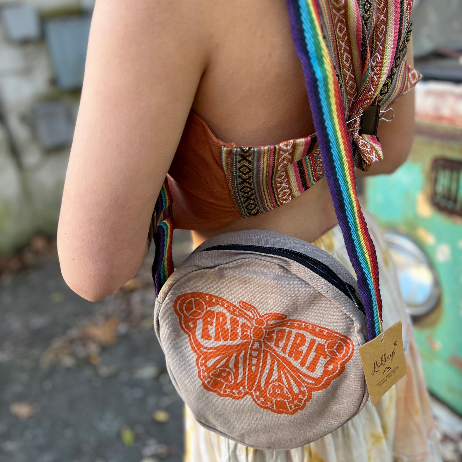 A woman wearing the butterfly Bohemian Round Print Cotton Crossbody Bag in front of herself.
