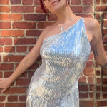 A woman wearing the Silver Sequin Disco Dress in front of a brick building.