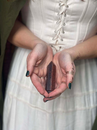 Woman holding a black crystal in her cupped hands.