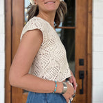  A woman wearing the natural Boho Knit Sweater Crochet V-Neck Top with some denim pants.