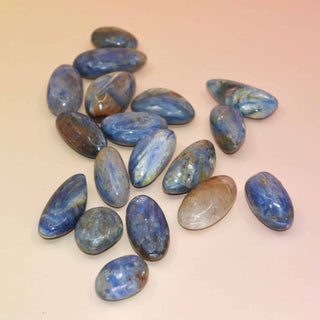 Collection of polished Blue Kyanite stones on peach background