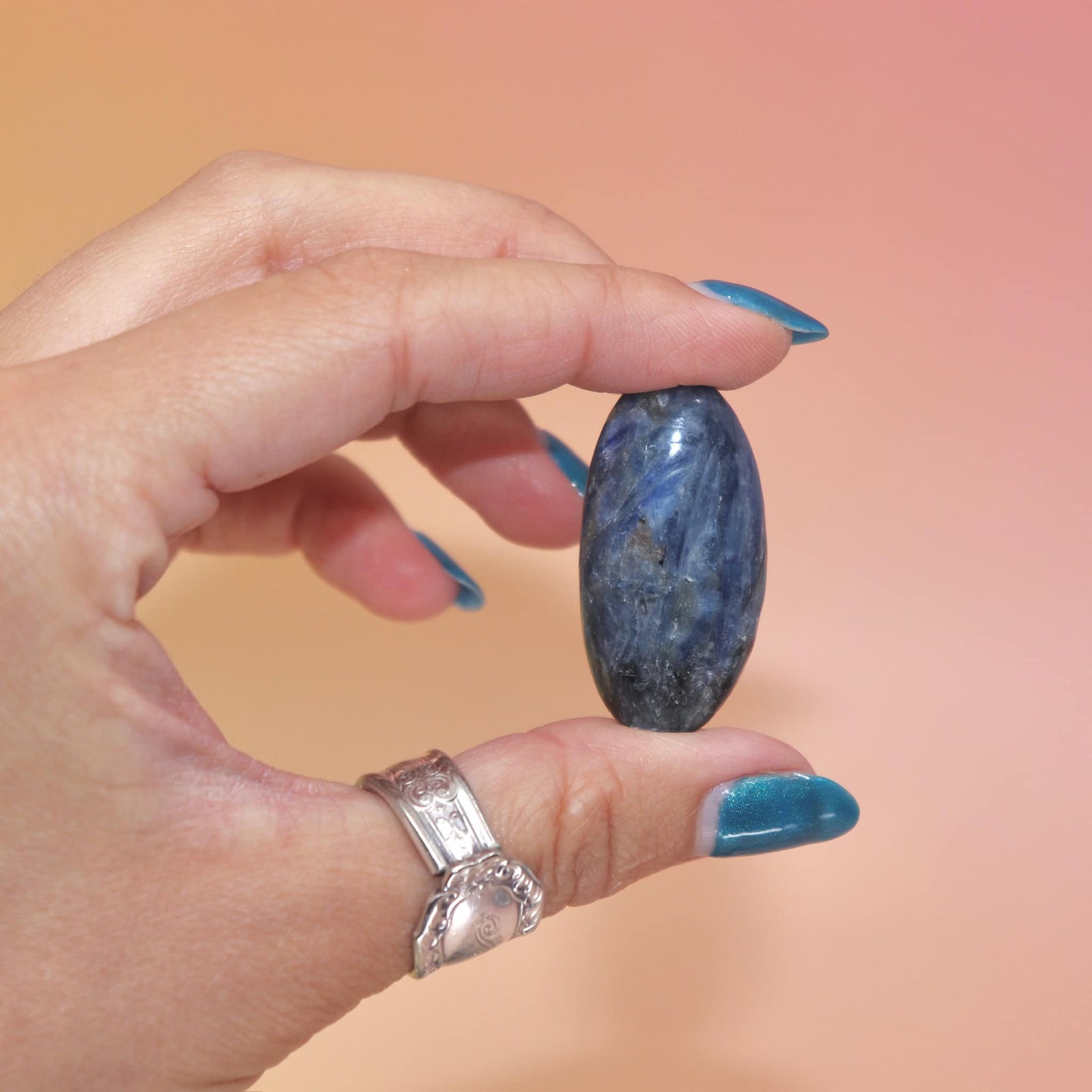 Hand holding a polished Blue Kyanite tumble